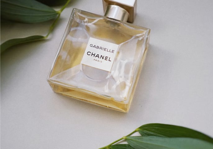 Chanel perfume bottle with some leave beside it